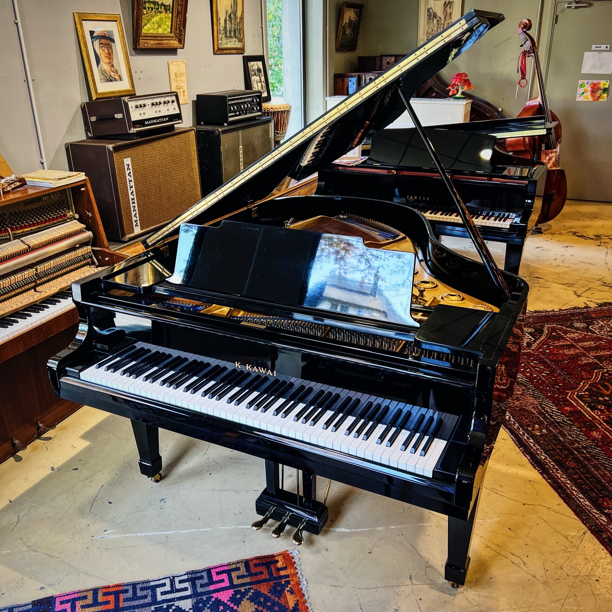 Piano à queue Kawai KG-3C d’occasion noir brillant de 1972, exposé dans le showroom Bonnaventure Piano à Caen.