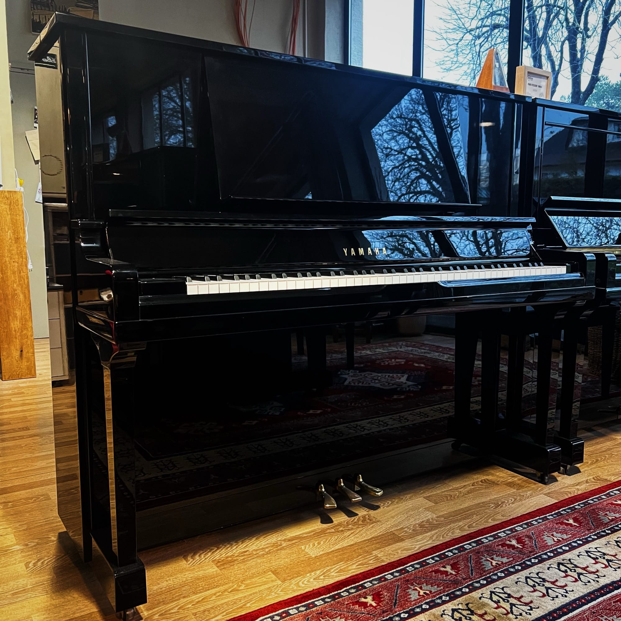Piano droit Yamaha UX30BL d’occasion 131 cm noir brillant fabrication japonaise présenté en showroom chez Bonnaventure Piano à Caen